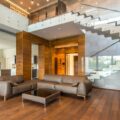Spacious modern living room with leather sofas and a glass staircase, showcasing luxury interior design.
